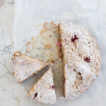 Summer Berry Cake on white parchment paper, two slices cut out
