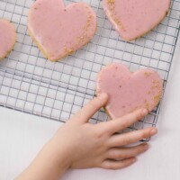 child reaching for a heart shaped cut out cookies
