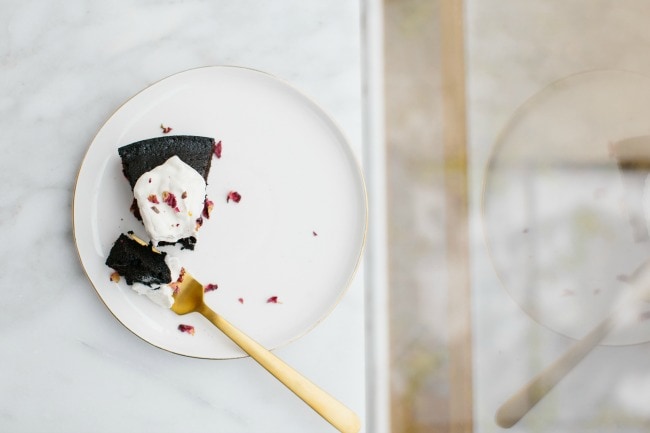 A slice of chocolate olive oil cake with whipped cream