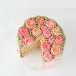 almond layer cake decorated with buttercream frosting piped into flowers