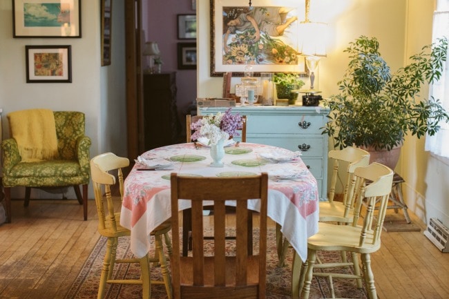 A table set up with a tablecloth and flowers, set for a meal.