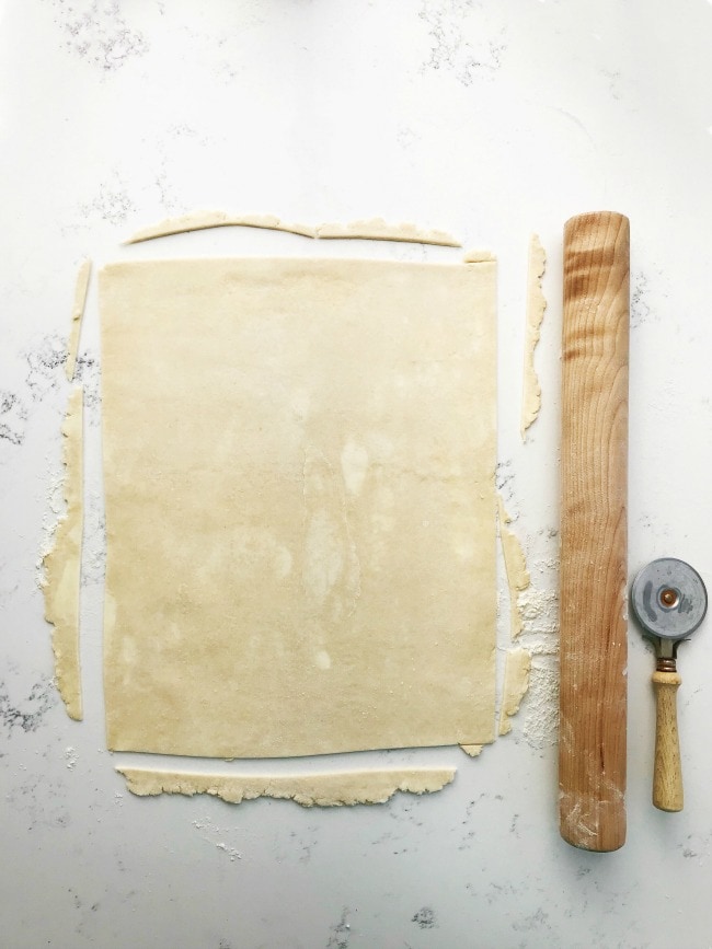 Pie dough on a surface with a cutter and rolling pin | Sarah Kieffer | The Vanilla Bean Blog