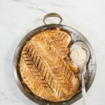 Peach Puff Pastry Pie in a circular pan with spoon