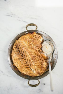 Peach Puff Pastry Pie in a circular pan with spoon