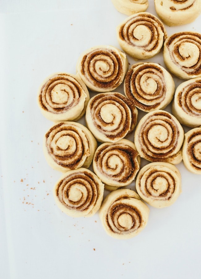 cinnamon roll dough cut into individual rolls and set to rise.