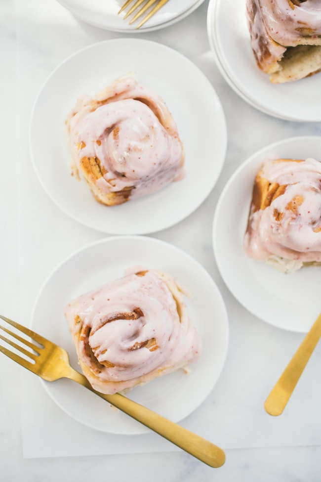 Strawberry Poppyseed Swirl Buns on white plates with gold forks