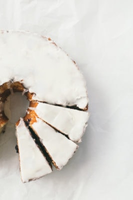 Blueberry Orange bundt cake with glaze, a few slices cut out of it.