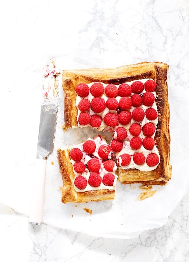 Raspberry Puff Pastry Tart with one slice out of it, and a knife to the left.