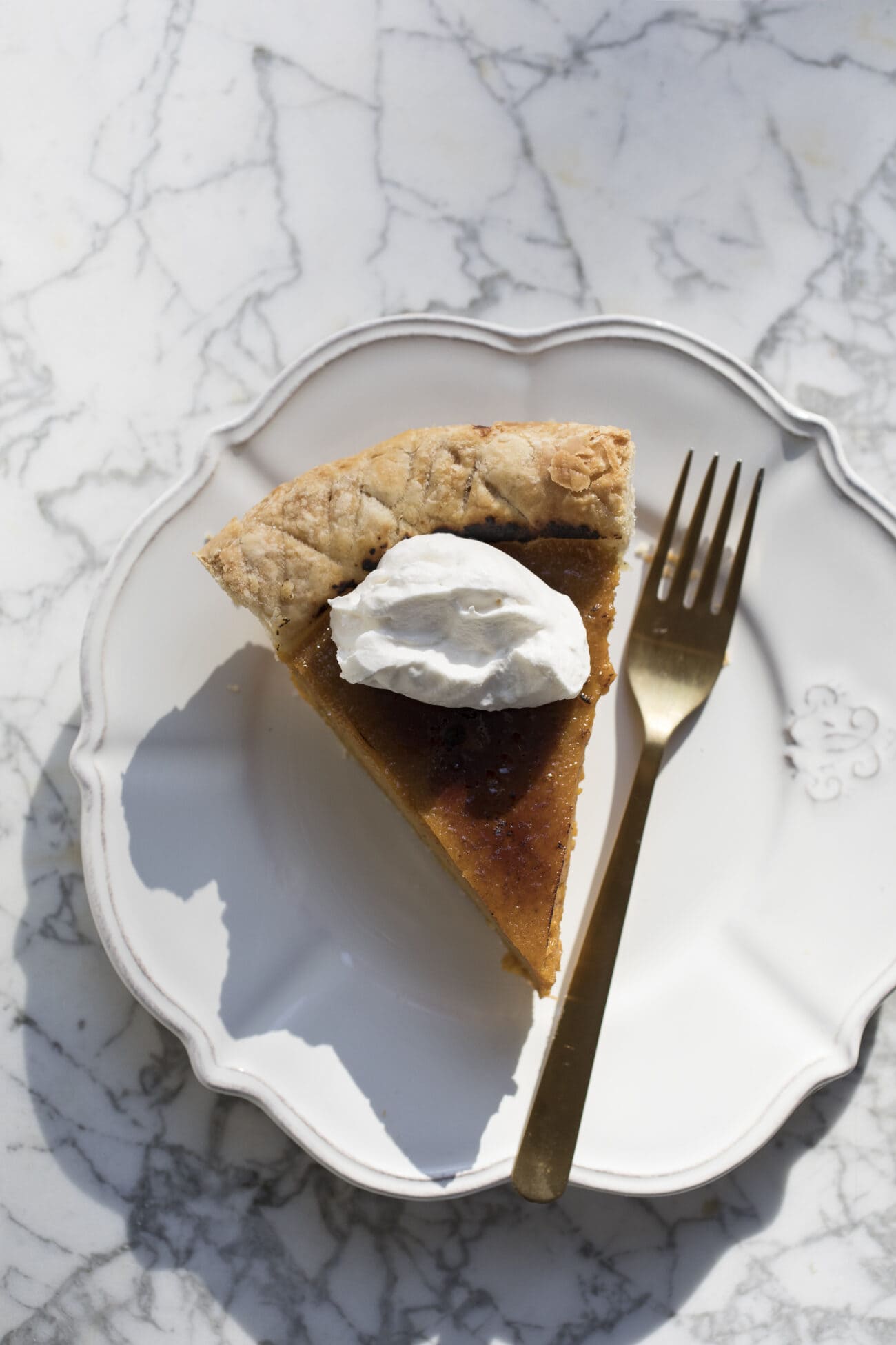 Slice of pie on a white plate with a fork beside it