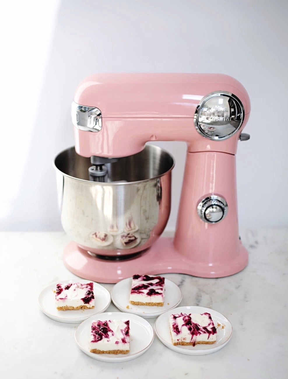 pink stand mixer in backround of photo with cranberry cheesecake bars