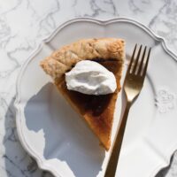 creme brulee pumpkin pie on white plate and gold fork