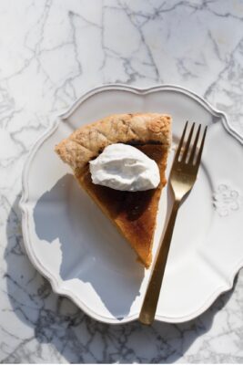 creme brulee pumpkin pie on white plate and gold fork