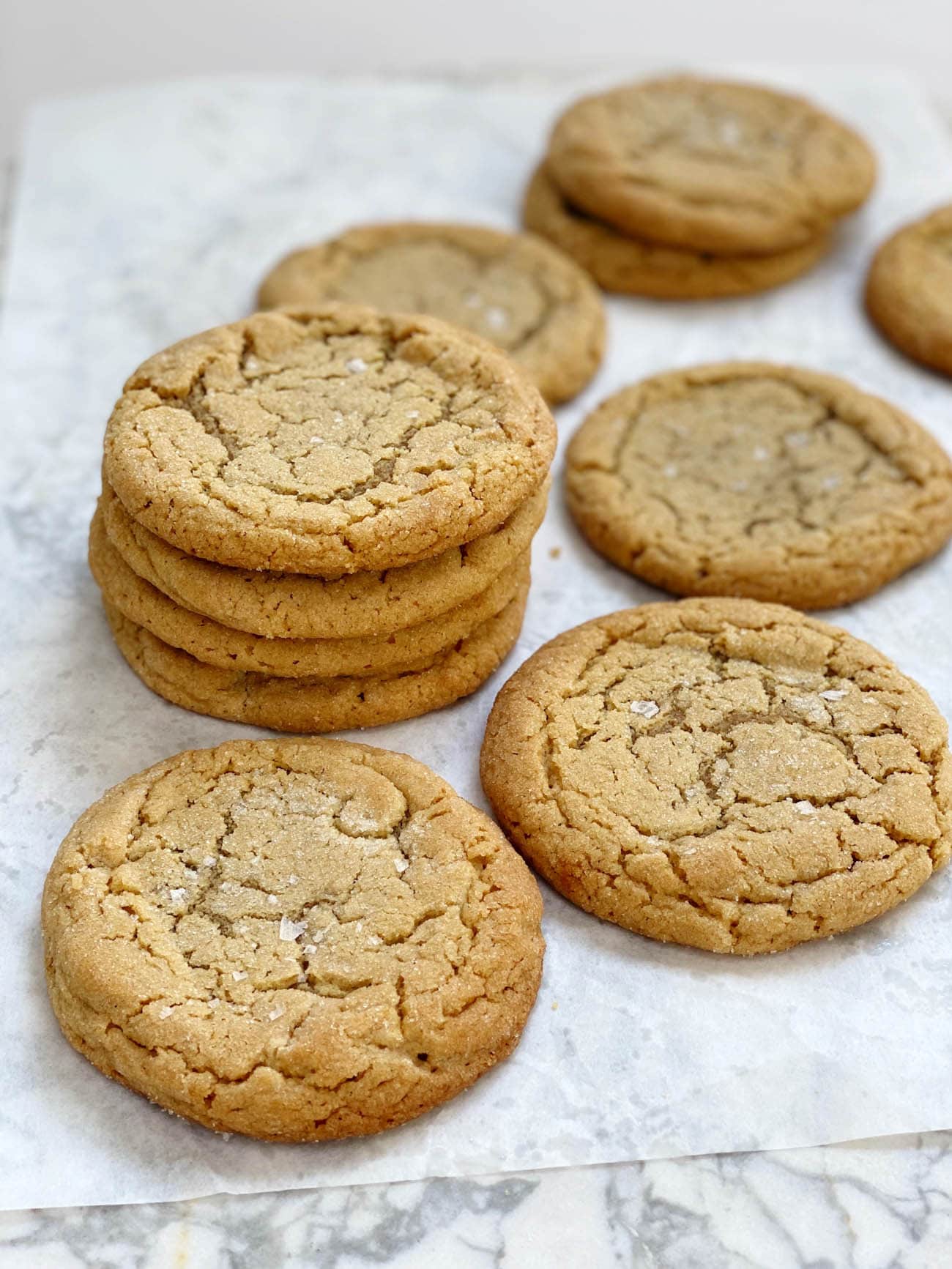 peanut butter cookies stacked on white parchment paper