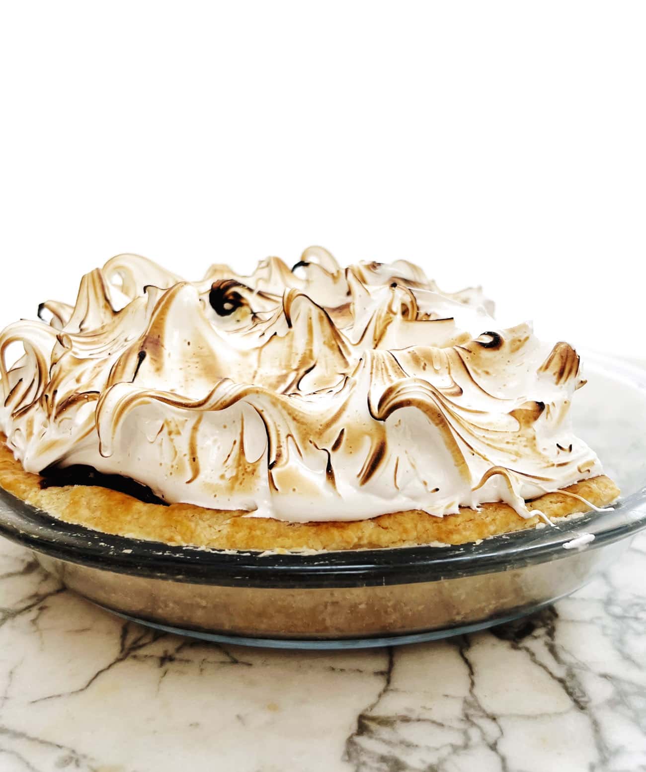 chocolate meringue pie in glass plate