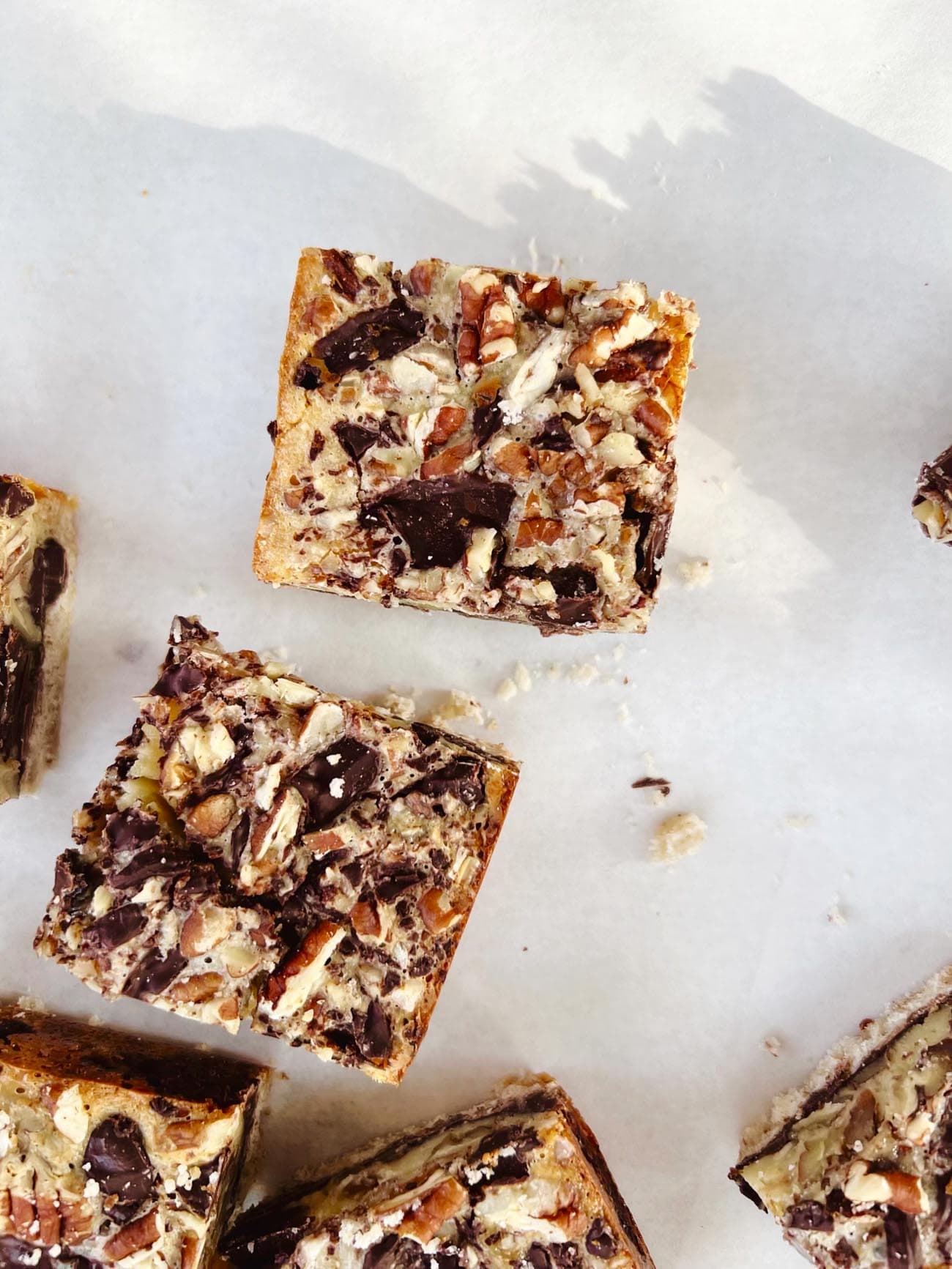 chocolate pecan pie bars on white parchment paper