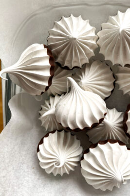 chocolate dipped meringues on parchment paper