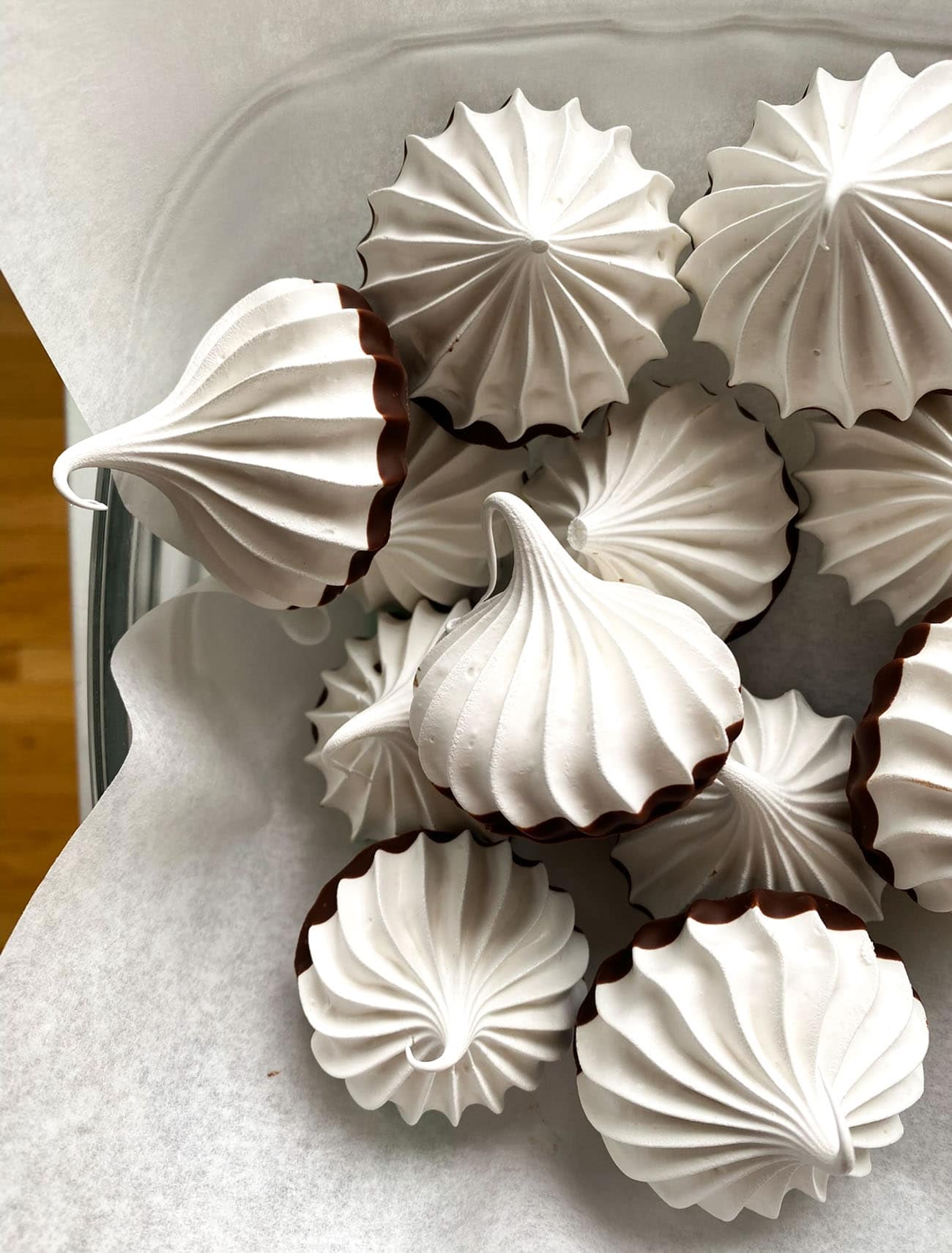 chocolate dipped meringues on parchment paper 