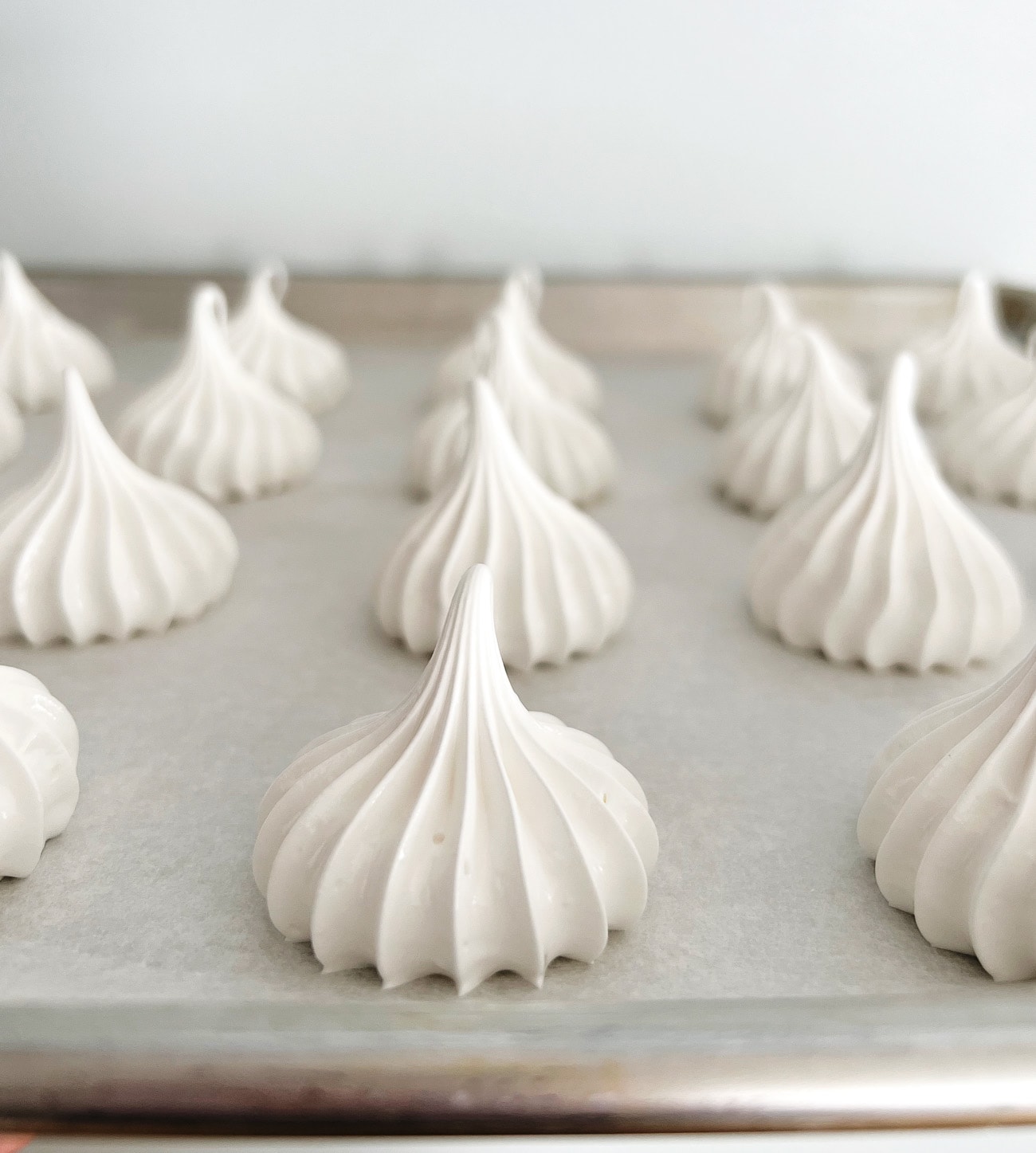 piped meringues on parchment