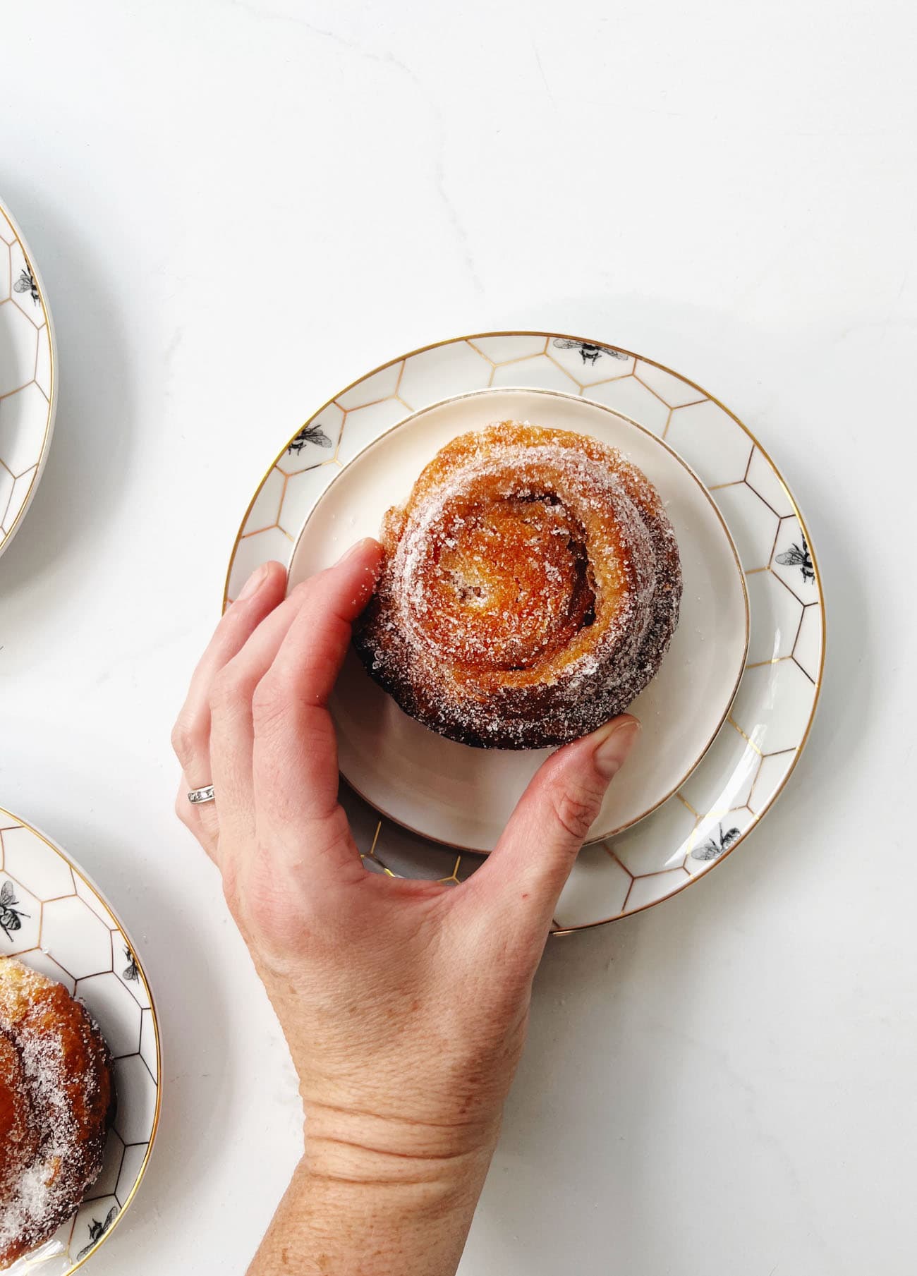 apple morning bun on plates with woman's hand