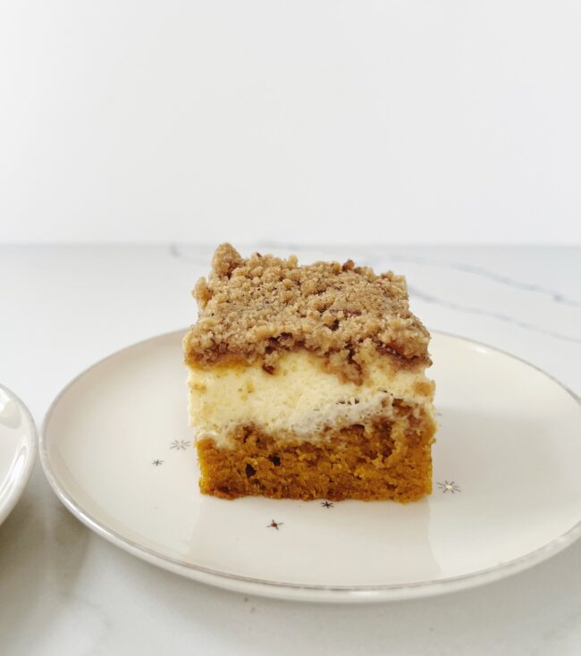 slice of pumpkin cream cheese coffee cake on white plate