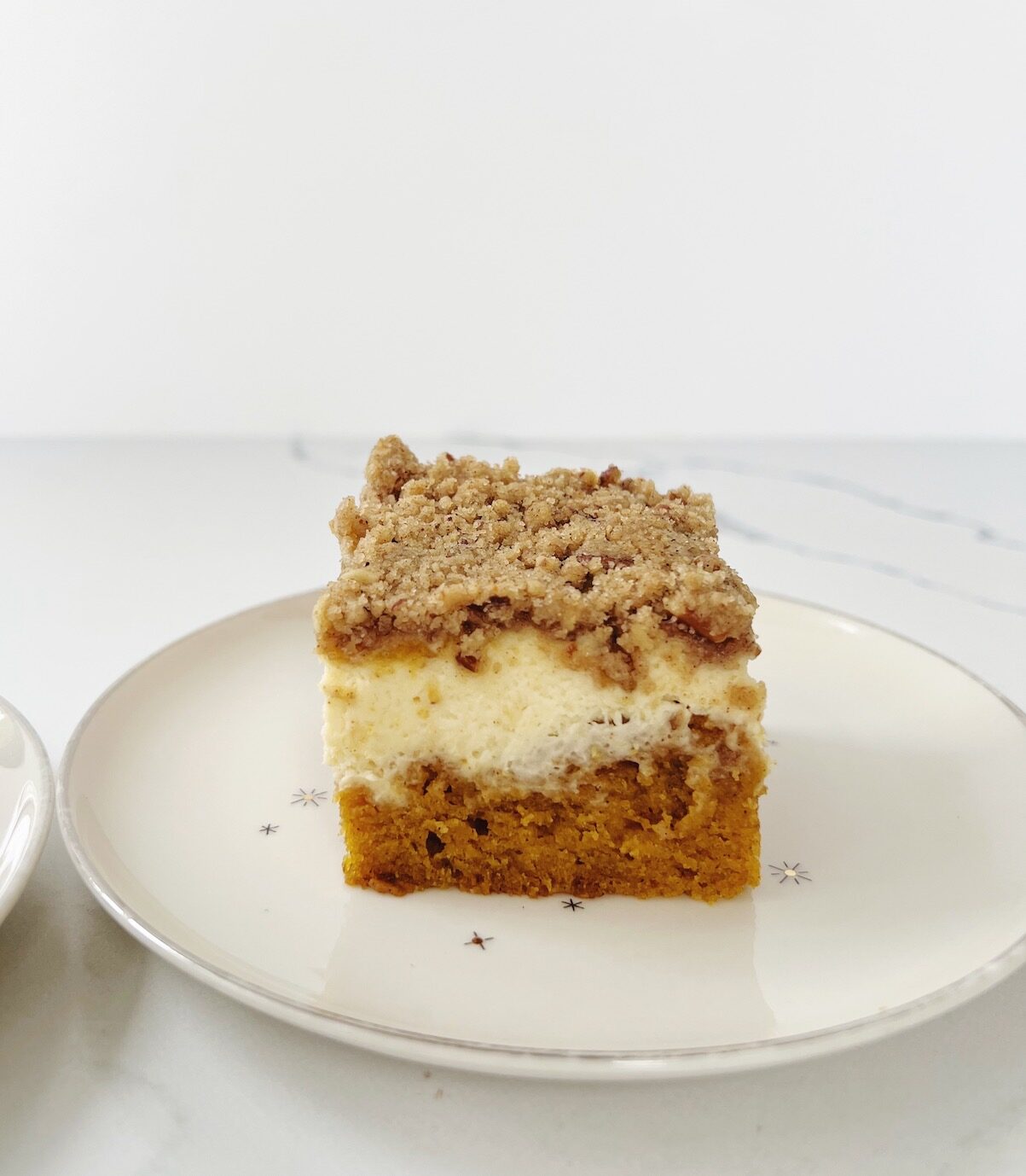 slice of pumpkin cream cheese coffee cake on white plate