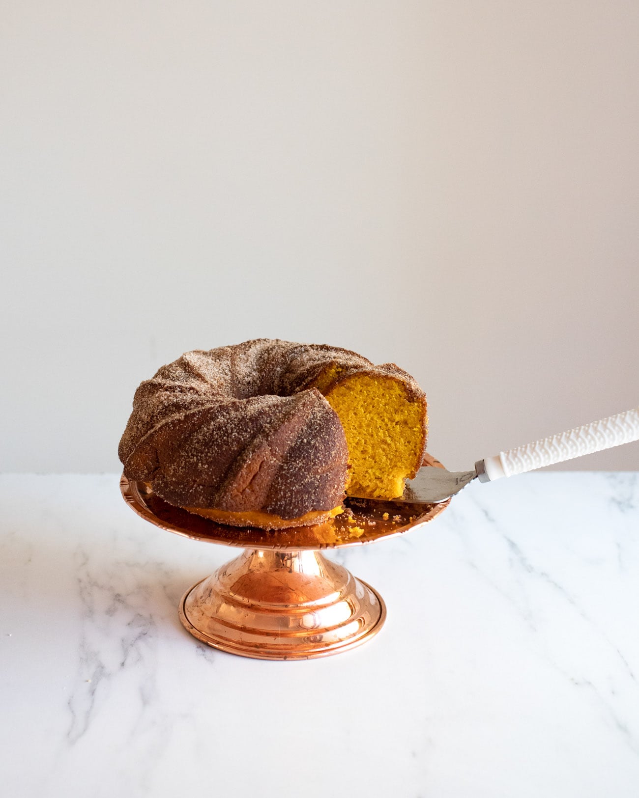 pumpkin bundt cake on pink cake stand