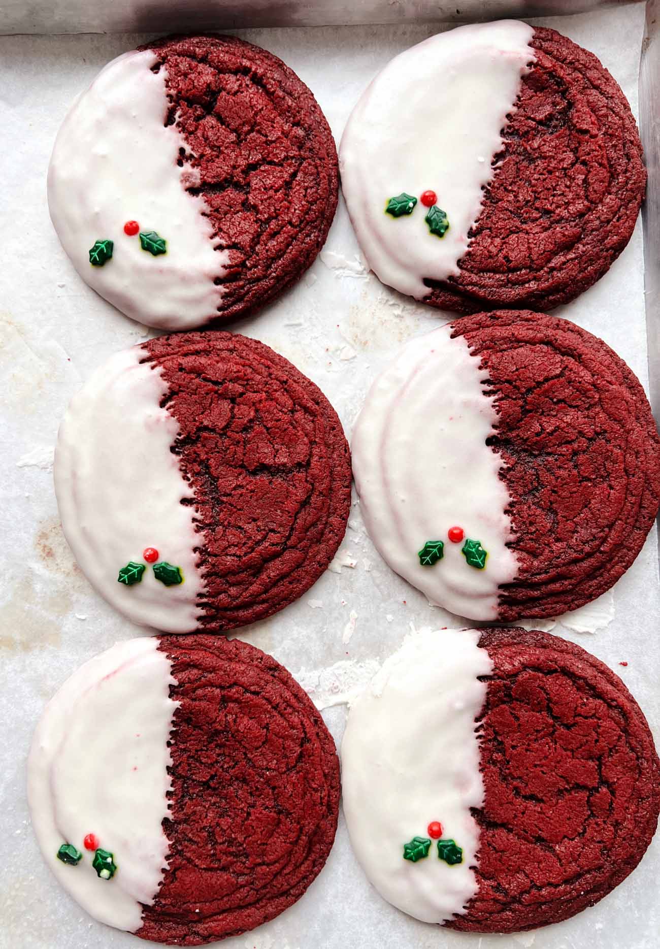 red velvet cookies with glaze on parchment paper