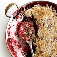 Cherry Rhubarb Crisp in a skillet pan with spoon