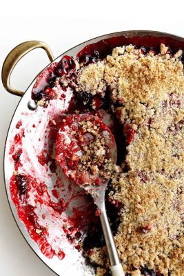 Cherry Rhubarb Crisp in a skillet pan with spoon