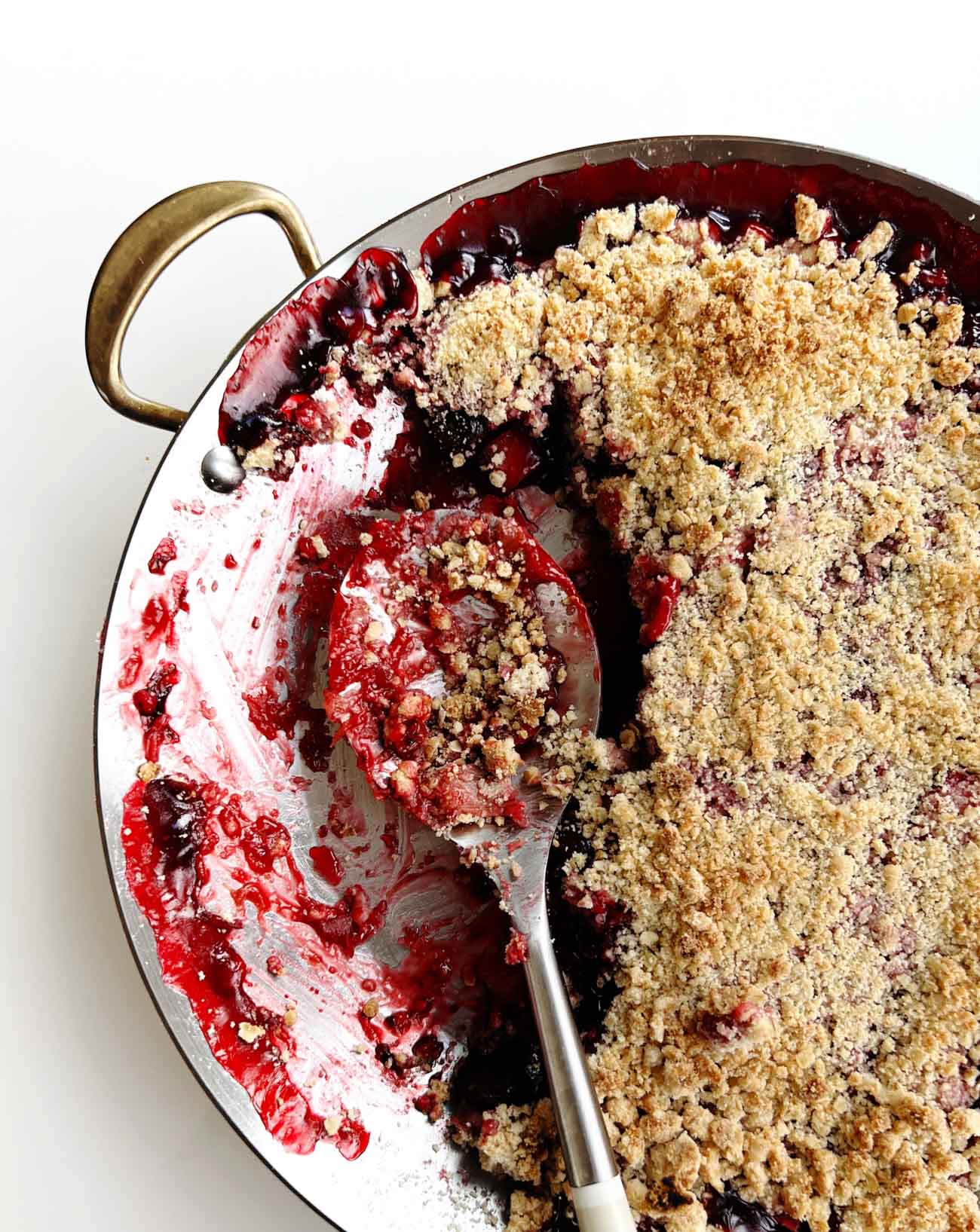 Cherry Rhubarb Crisp in a skillet pan with spoon