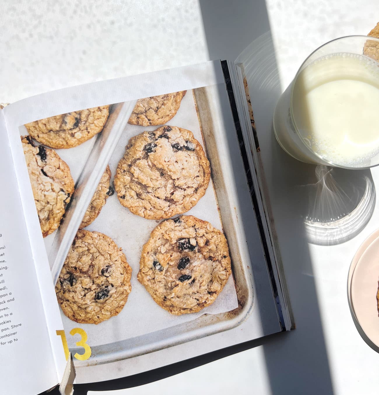 100 cookies cookbook with a glass of milk to its right