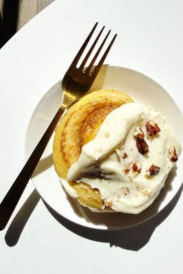 carrot cake cinnamon rolls on white plate with fork