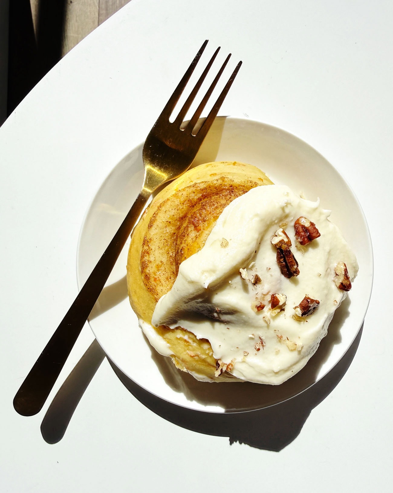 carrot cake cinnamon rolls on white plate with fork