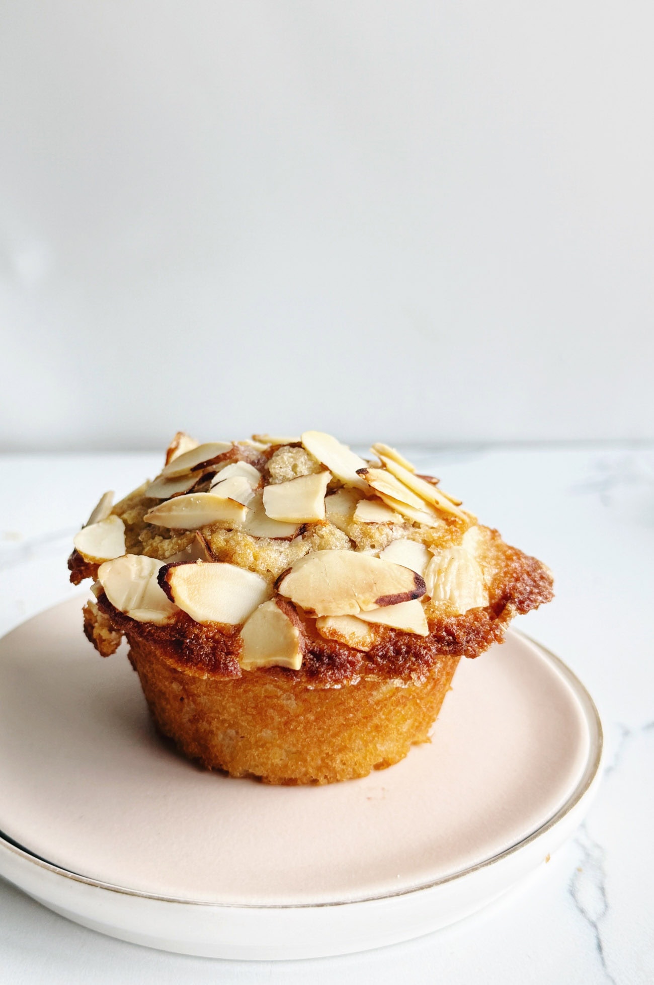 Cherry almond muffin with sliced almonds on top, fresh and inviting.