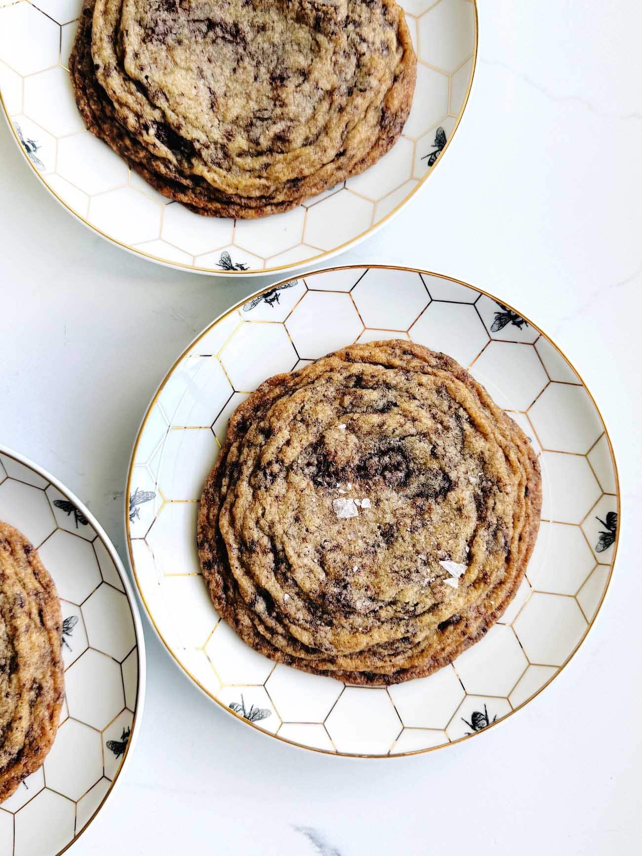 pan banging brown butter chocolate chip cookies on white plates