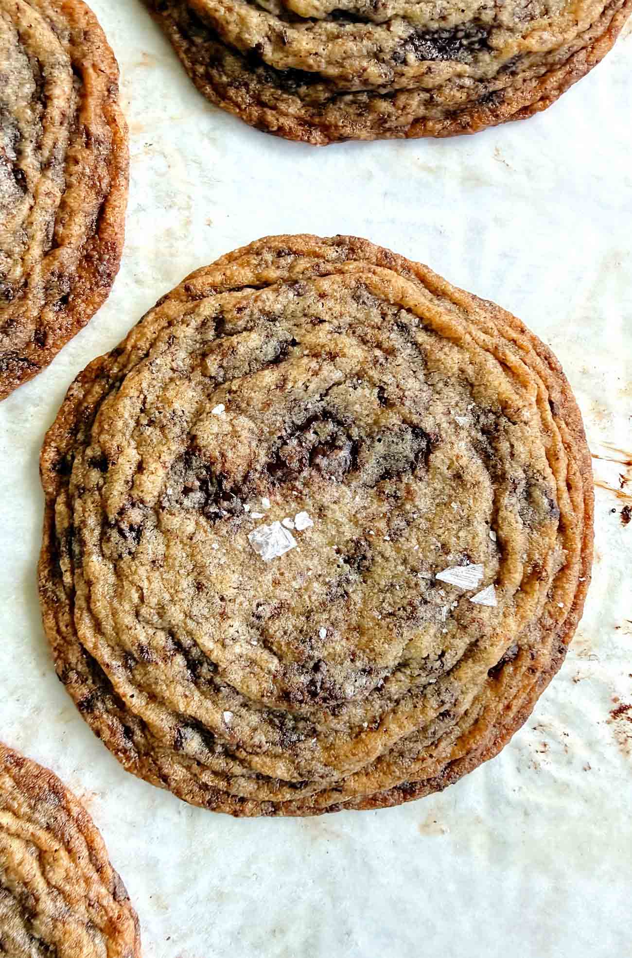 pan banging brown butter chocolate chip cookies on parchment paper