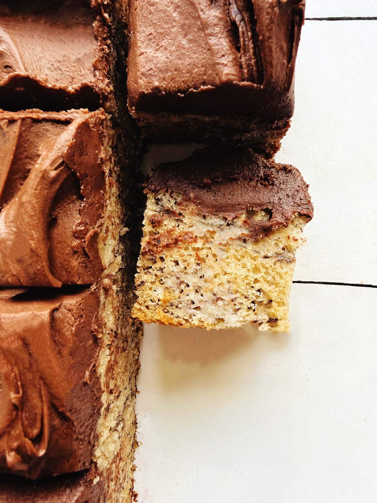 Close-up of banana bread bars topped with fudge buttercream frosting.